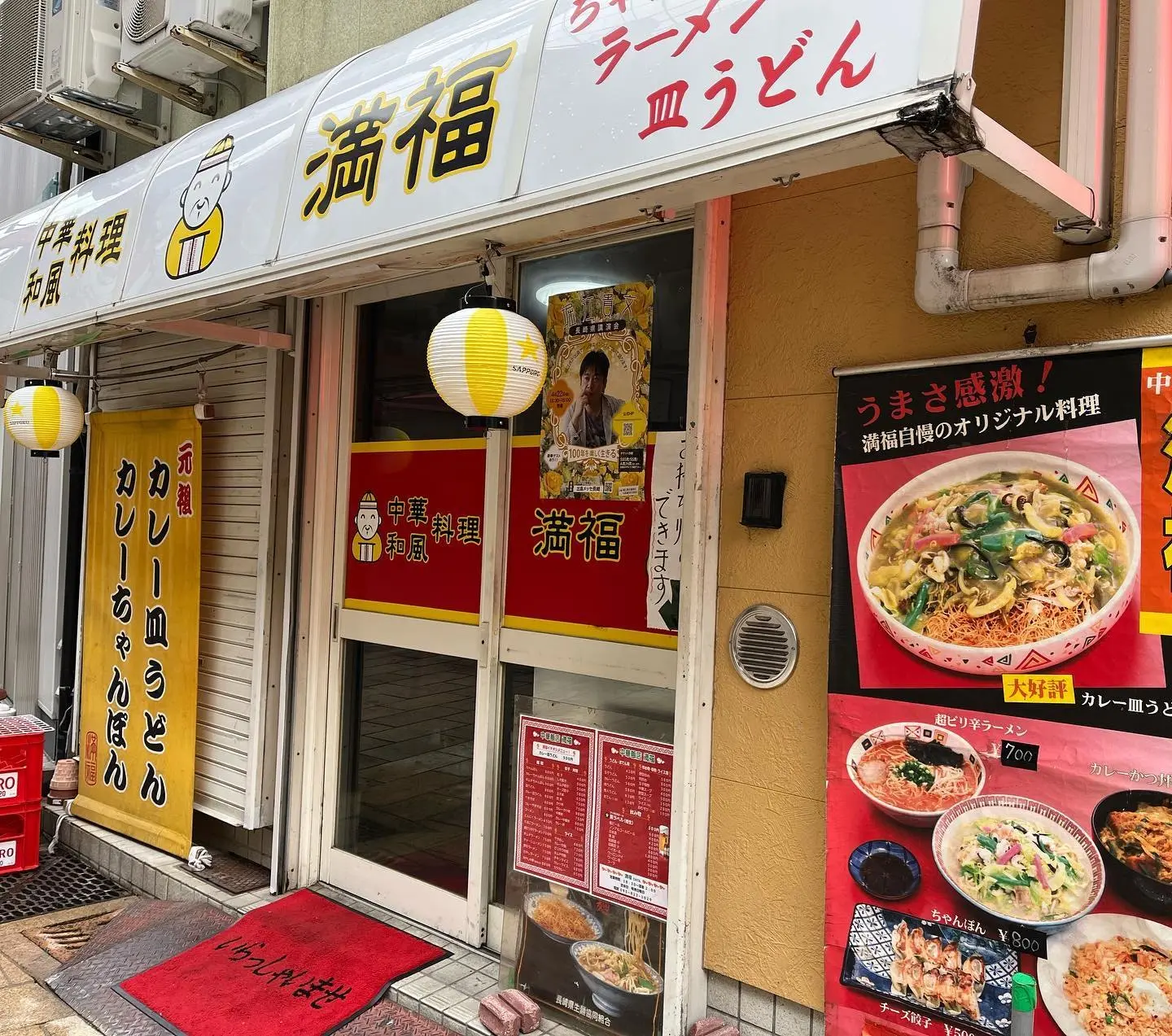 黄色い看板と提灯の店構え