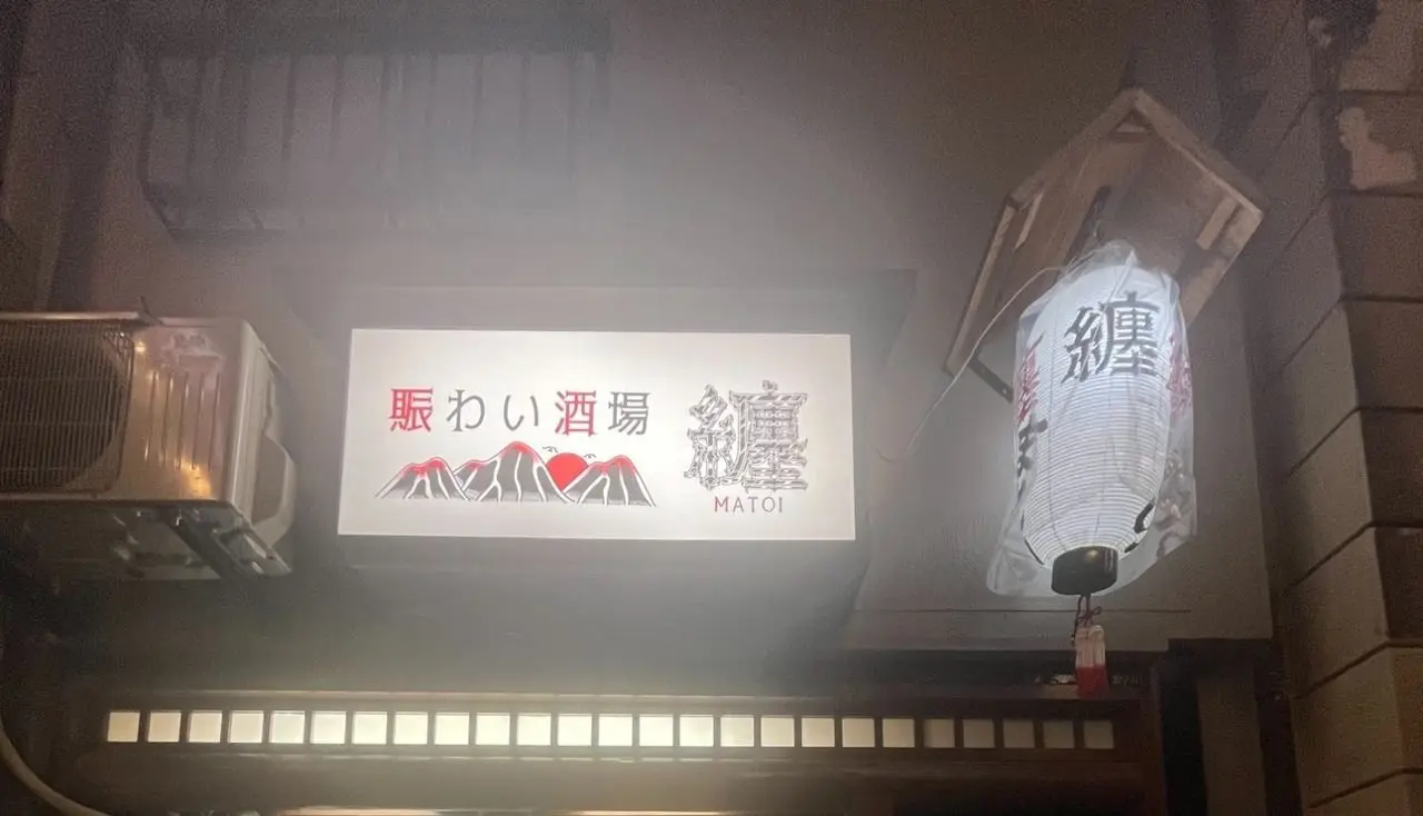 The sign and lantern lit at night
