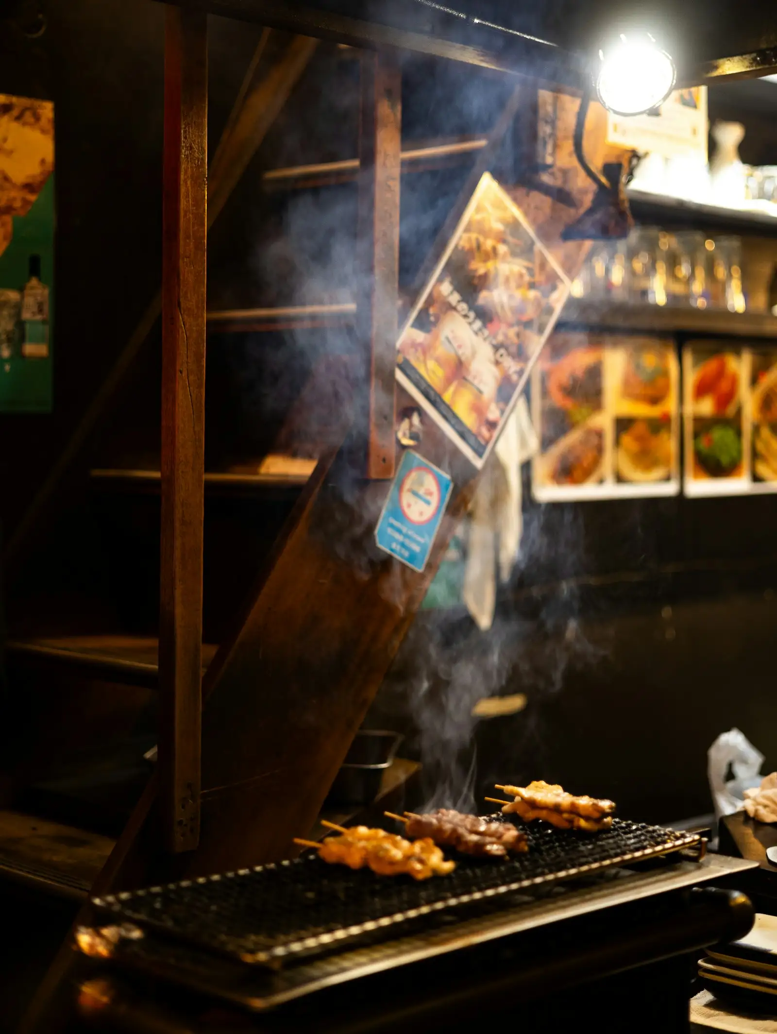 煙の立つ炭火の上の串焼き(イメージ)